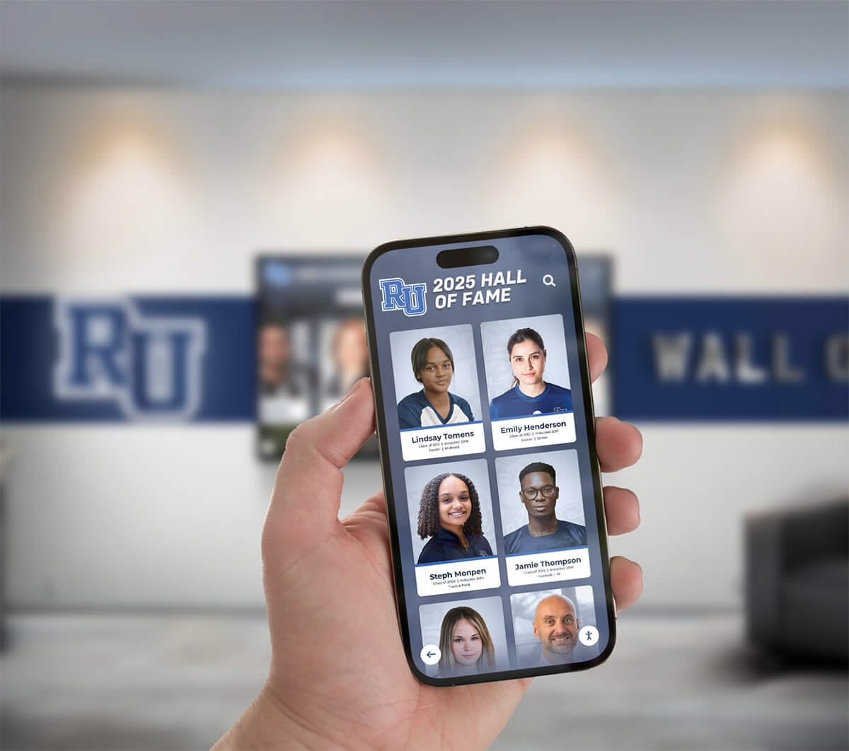 Visitor using a mobile phone to access a digital hall of fame platform in a university lobby Hand holding a phone showing a hall of fame app in a university lobby